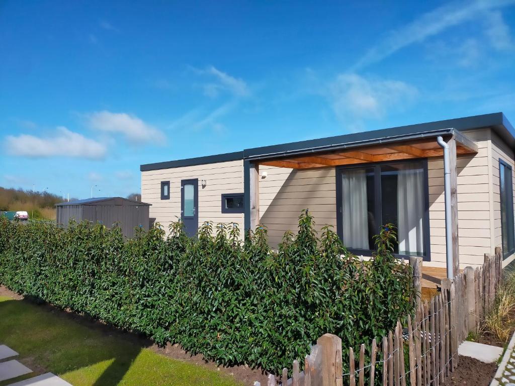 une maison avec un toit noir et une clôture dans l'établissement Beachside Vakantiepark, à Blankenberge