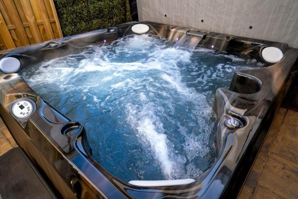 a jacuzzi tub with blue water in it at Antrim House Guest Rooms & Suites in Portrush