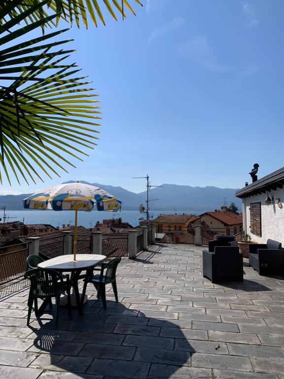 einen Tisch und Stühle mit Sonnenschirm auf einer Terrasse in der Unterkunft Franziska's Place in Cannero Riviera