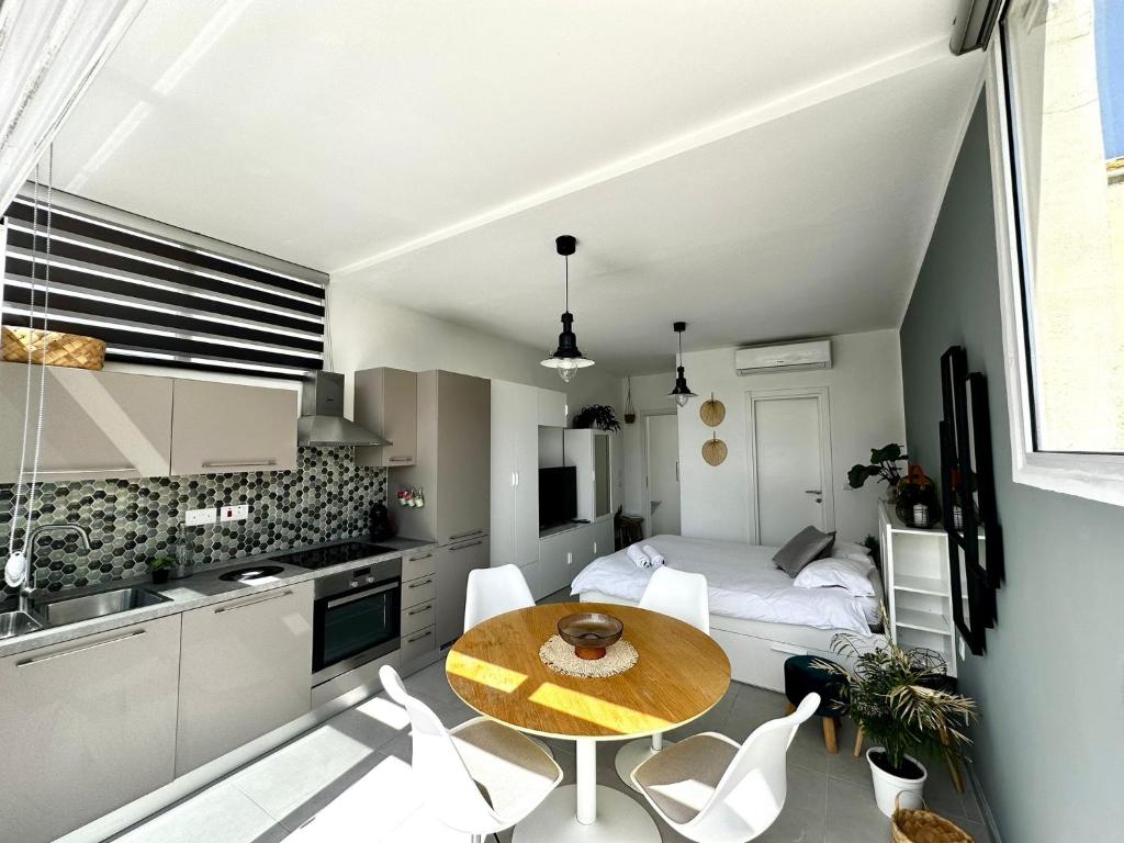 uma pequena cozinha com uma mesa e uma cama num quarto em Cosy Penthouse in Hamrun - Walking distance to Valletta em Hamrun