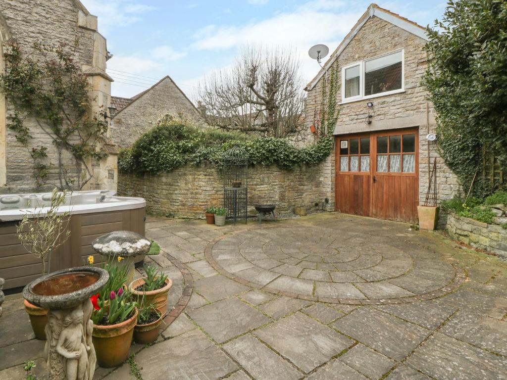 a backyard with a stone courtyard with a wooden door at The Coach House in Somerton