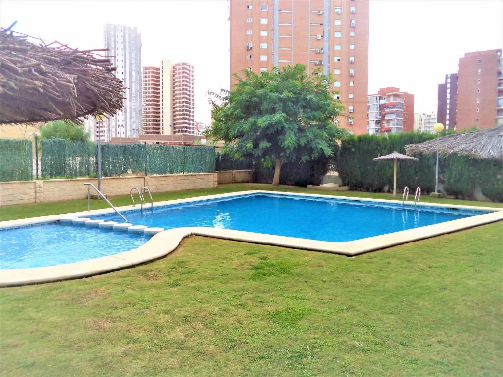 a swimming pool in a city with tall buildings at Ola Azul Sea View Apartment in Benidorm