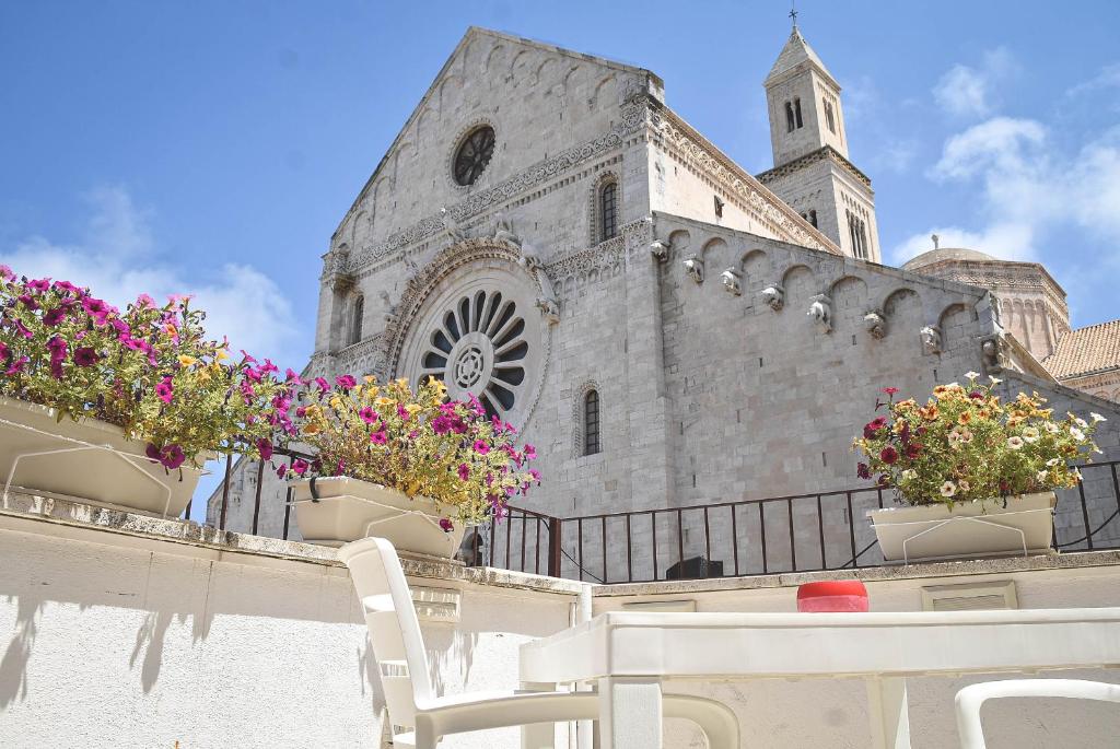 a church with a table and chairs and flowers at The Cathedral House in Bari
