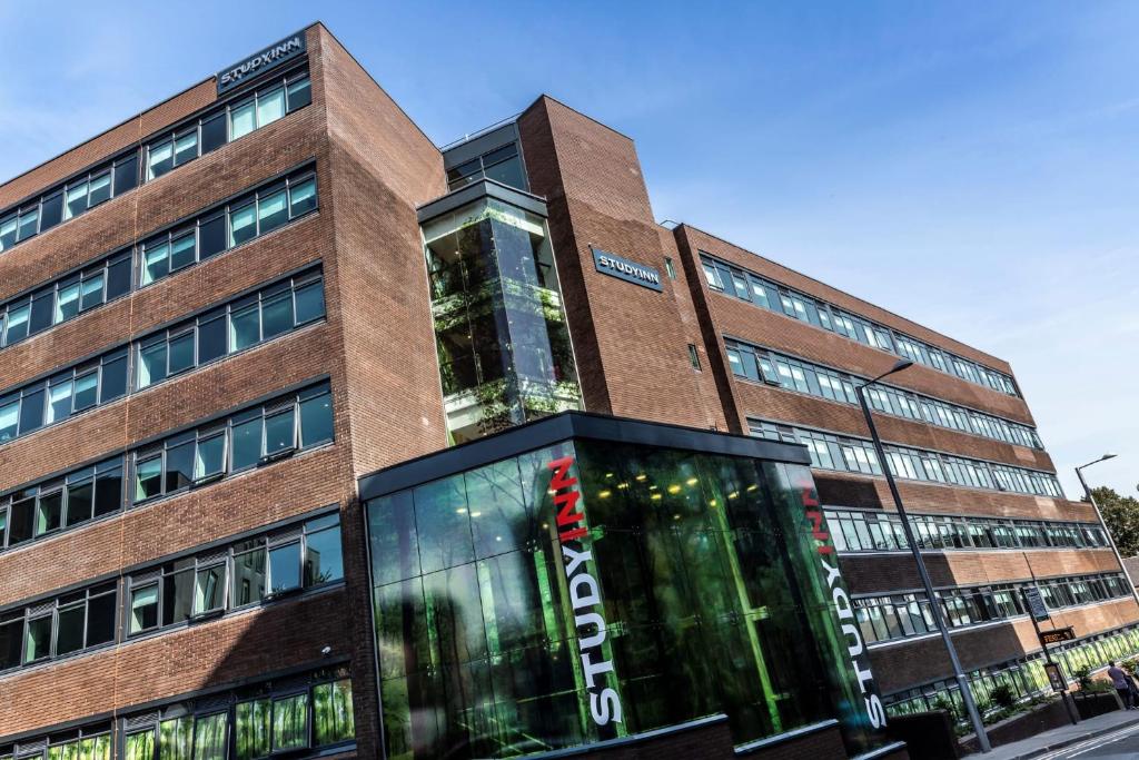 a tall brick building with a sign on it at For Students Only Studios and Ensuite Bedrooms with Shared Kitchen at Talbot Street in Nottingham in Nottingham