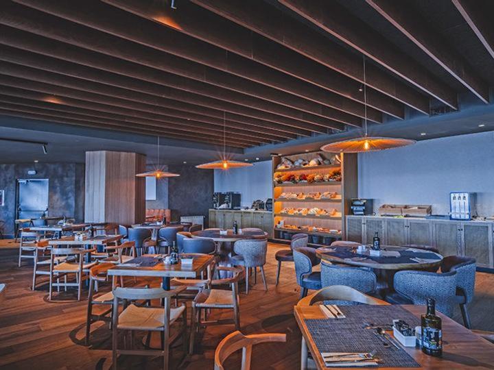 a restaurant with tables and chairs in a room at The Mountains Hotel in Sierra Nevada