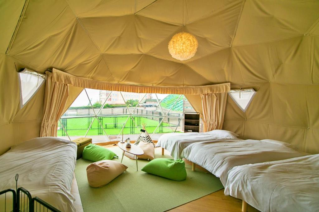 Zimmer mit 4 Betten in einem Zelt in der Unterkunft glampark Kaiyokaku Aichi in Gamagori