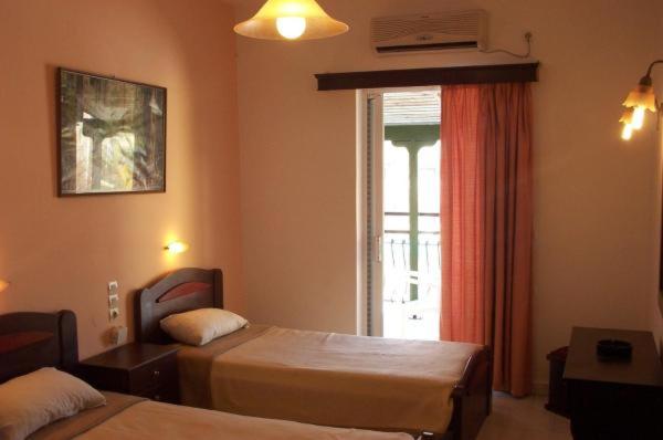 Habitación de hotel con 2 camas y ventana en Perkes Hotel Complex en Laganas