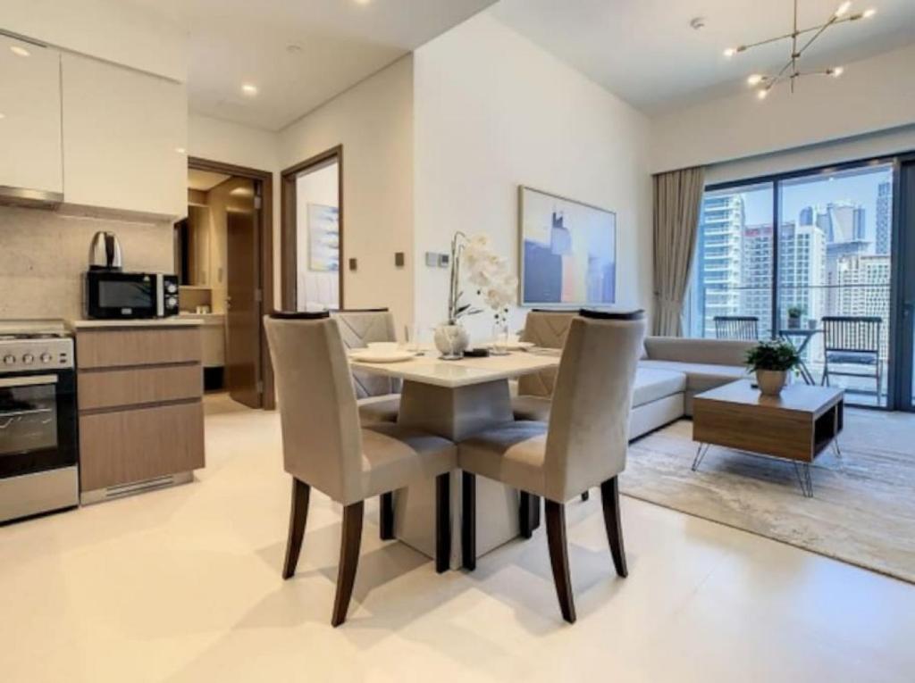 cocina y sala de estar con mesa y sillas en Key View - Burj Royale, en Dubái