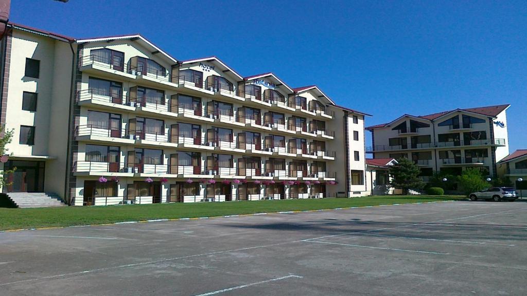 um grande edifício com um parque de estacionamento em frente em Hostel Stefania em Costinesti