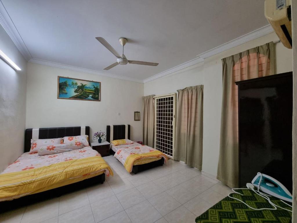 una camera con 2 letti e un ventilatore a soffitto di HELLO HOMESTAY a Nibung Tebal