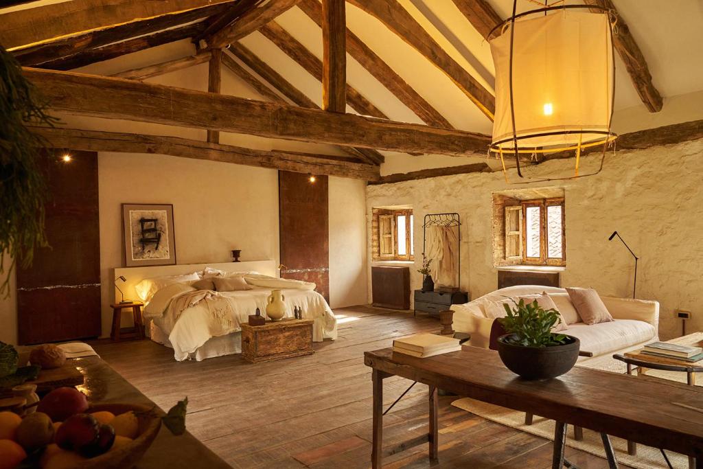 een grote kamer met 2 bedden en een tafel bij SOLO PALACIO - Boutique Hotel & Spa in Llanuces