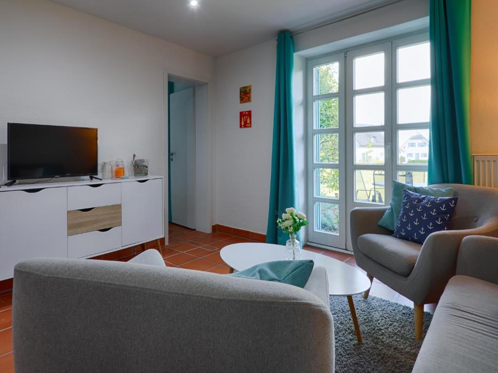 un salon avec un canapé et une télévision dans l'établissement Feriendorf Rugana - Klassik Ferienwohnung mit 2 Schlafzimmern und 2 Terrassen D55, à Dranske