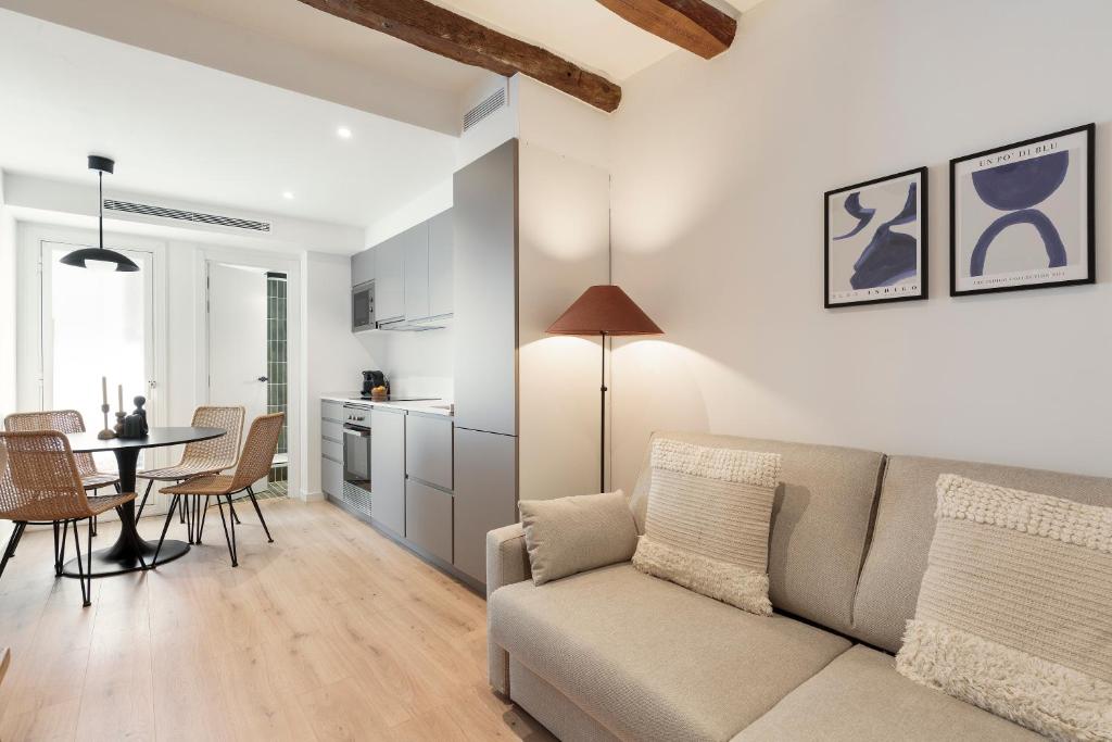 sala de estar con sofá y mesa en Vibe Apartments by Olala Homes, en Hospitalet de Llobregat