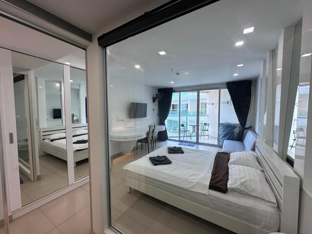 a bedroom with a bed and a balcony with a desk at Sands Condo Pattaya 82 by ThaiminatorPattaya in Pattaya South