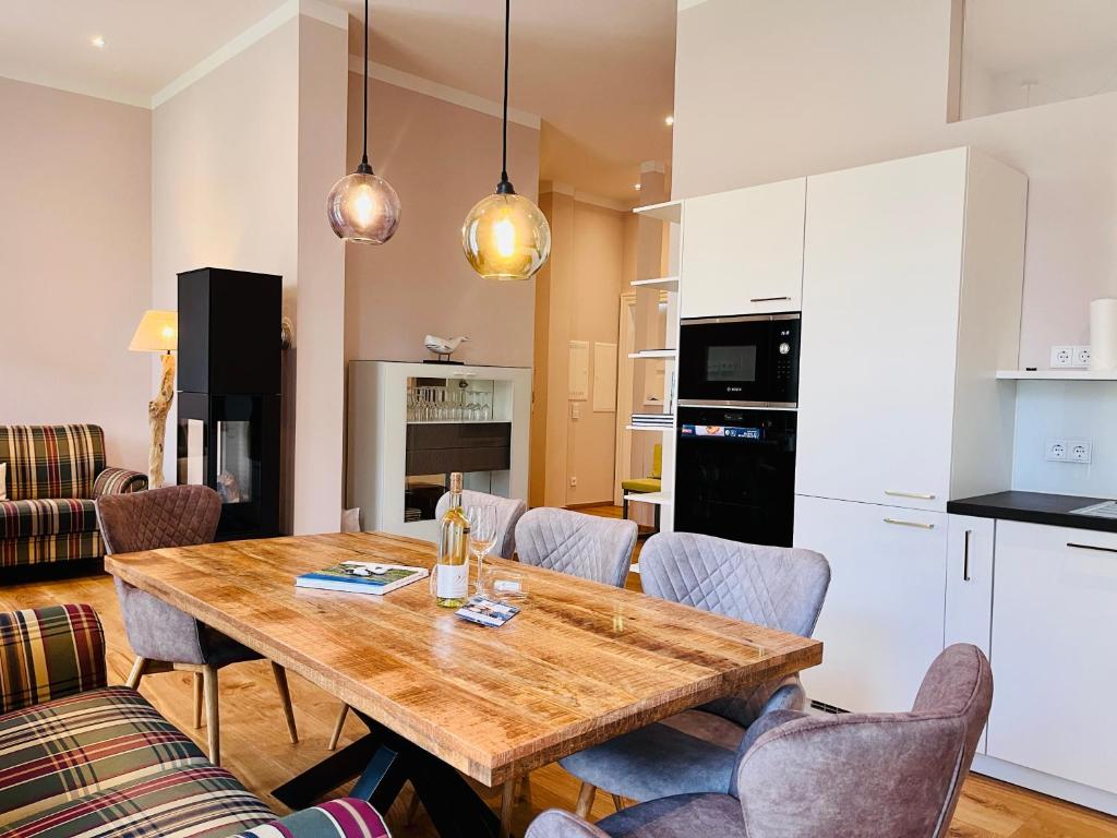 uma cozinha e sala de jantar com uma mesa de madeira e cadeiras em Putbus Ferienwohnung Kleine Auszeit em Putbus