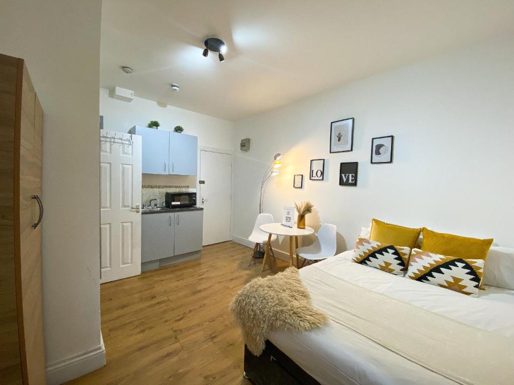 a bedroom with a bed and a kitchen with a table at Holland Road Stays in London