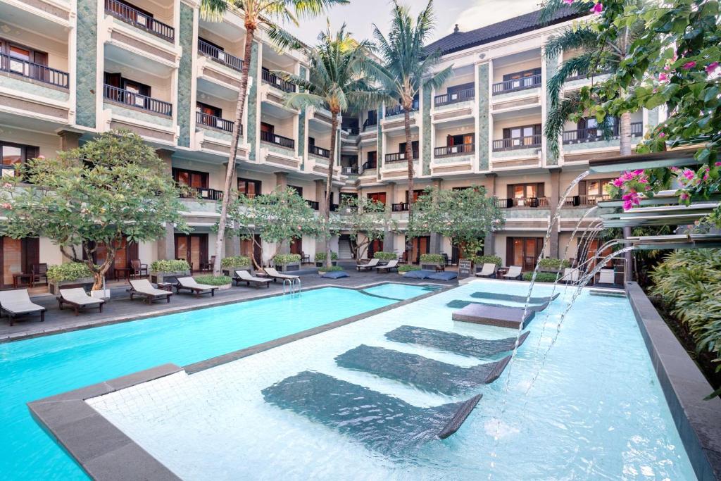 a swimming pool in the courtyard of a building at The Vira Bali Boutique Hotel & Suite in Kuta