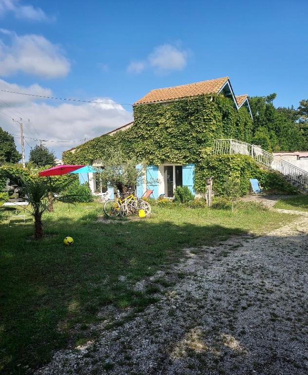une maison recouverte de lierre à côté d'une cour dans l'établissement Villa Oleronaise, au Château-dʼOléron