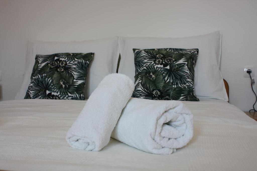 a white towel on a bed with two pillows at Apartments Adria in Tribunj