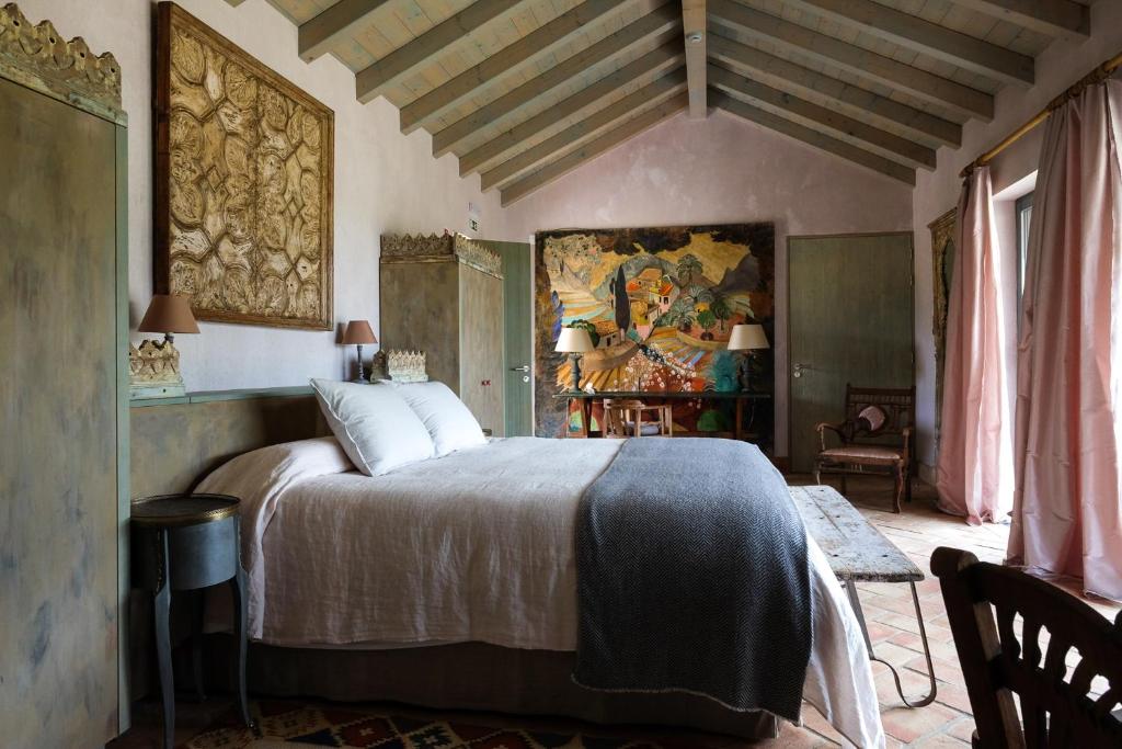 1 dormitorio con 1 cama y una pintura en la pared en Monte da Bela Raposa, en Pavia