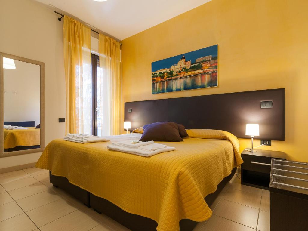 a bedroom with a large bed with a yellow blanket at Al Molì Affittacamere in Cagliari