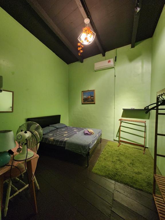 um quarto com uma cama e uma parede verde em Relish The Moment em Malaca