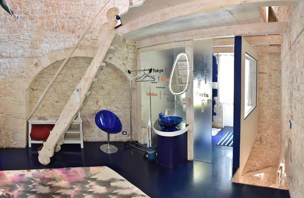 um quarto com uma escada e uma cadeira azul em l'angolo di Gaudì, alcoba Fascinosa em Putignano