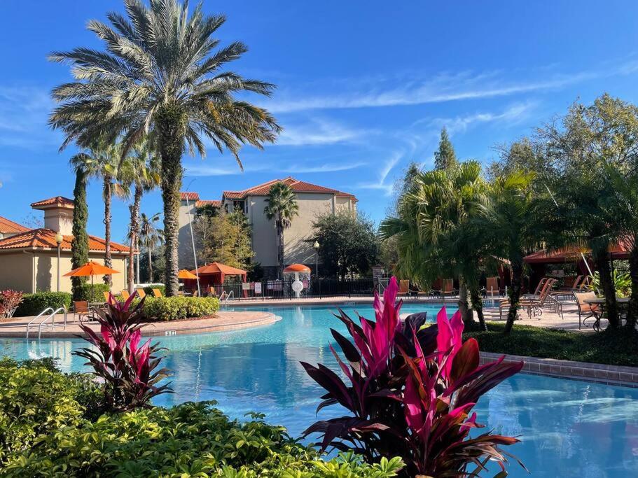 - une piscine dans un complexe avec des palmiers dans l'établissement Tuscana Gem! 2 bed 2 bath condo near Disney & Golf, à Kissimmee