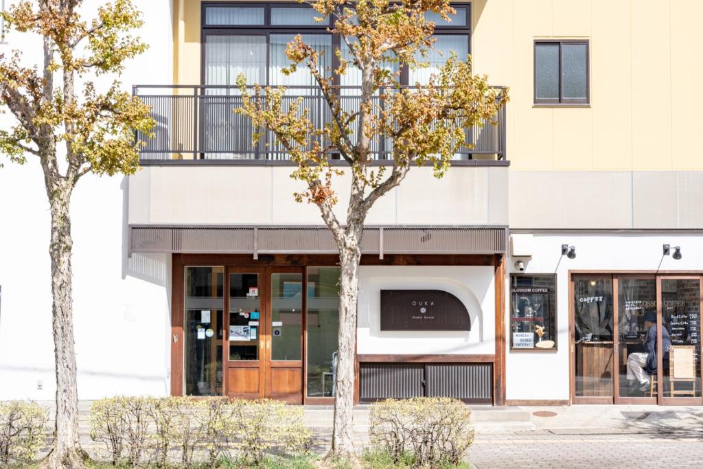 duas árvores em frente a um edifício em Guest House Ouka em Takayama