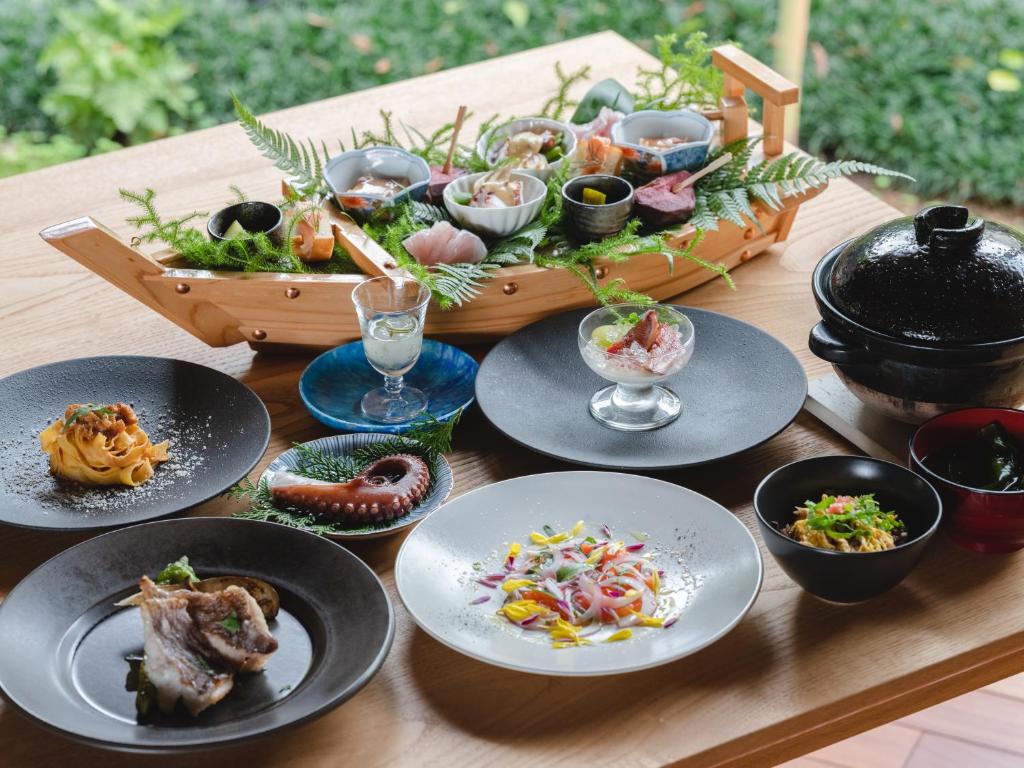 uma mesa de madeira com pratos de comida em sea-auberge shitsumi 海のオーベルジュ志積 em Obama