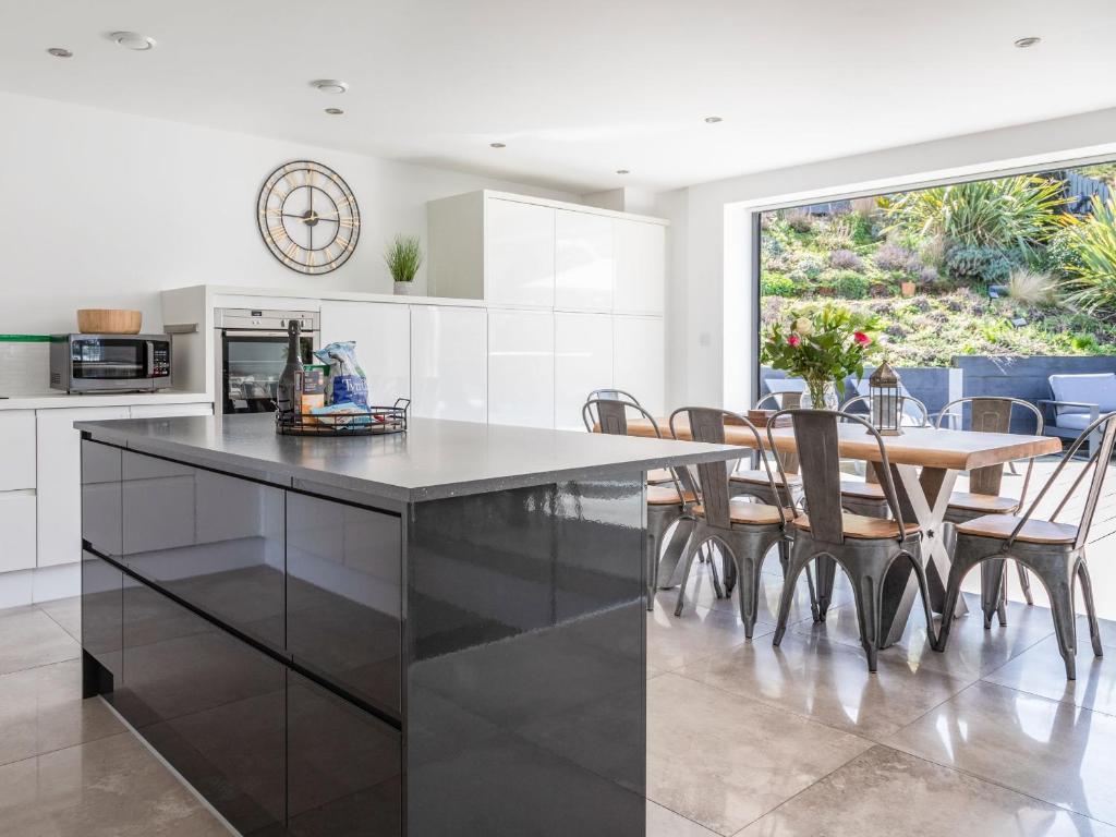 a kitchen with a table and chairs and a large window at 7 Beachdown in Kingsbridge