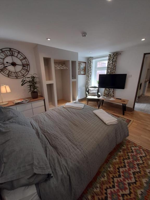a bedroom with a large bed and a television at cosy quiet 1 bedroom apartment Carrington in Nottingham