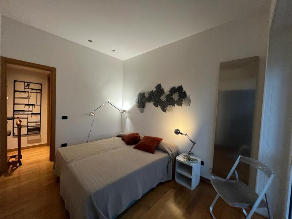 a bedroom with a bed and a chair and a lamp at Home 10 in Milan
