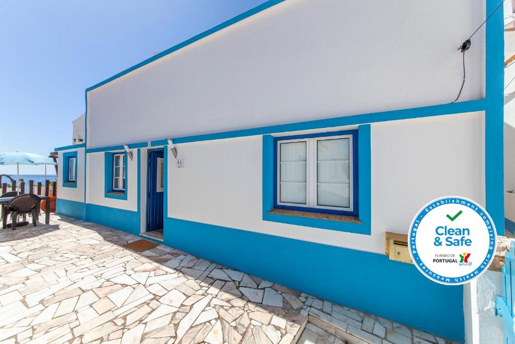 um edifício azul e branco com uma placa que diz limpo e seguro em B54 - Casa Azul in Burgau em Budens