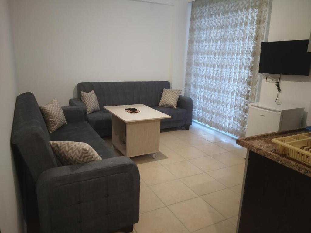 - un salon avec un canapé et une table dans l'établissement ELSİRA APART, à Sidé