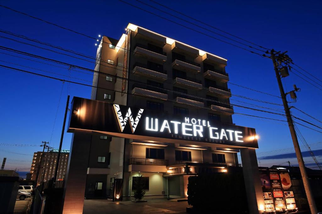 富山ホテルウォーターゲート富山 レジャーホテル 大人用ホテル的大楼前的酒店水门标志
