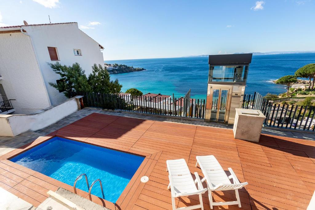 a patio with two chairs and a swimming pool at RNET - Casa 3 - Vista Mar Almadrava Roses in Roses