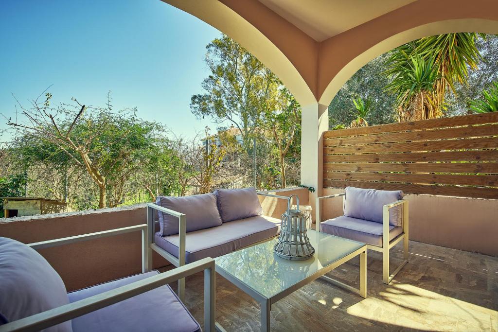 a patio with two chairs and a glass table at Maria House in Lithakia
