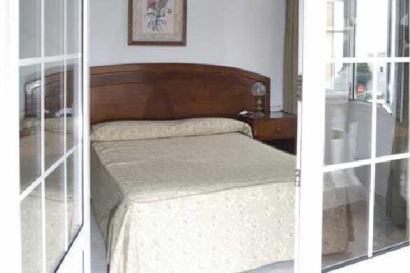 2 fotos de un dormitorio con 1 cama en una habitación en Hotel Boomerang, en Valverde