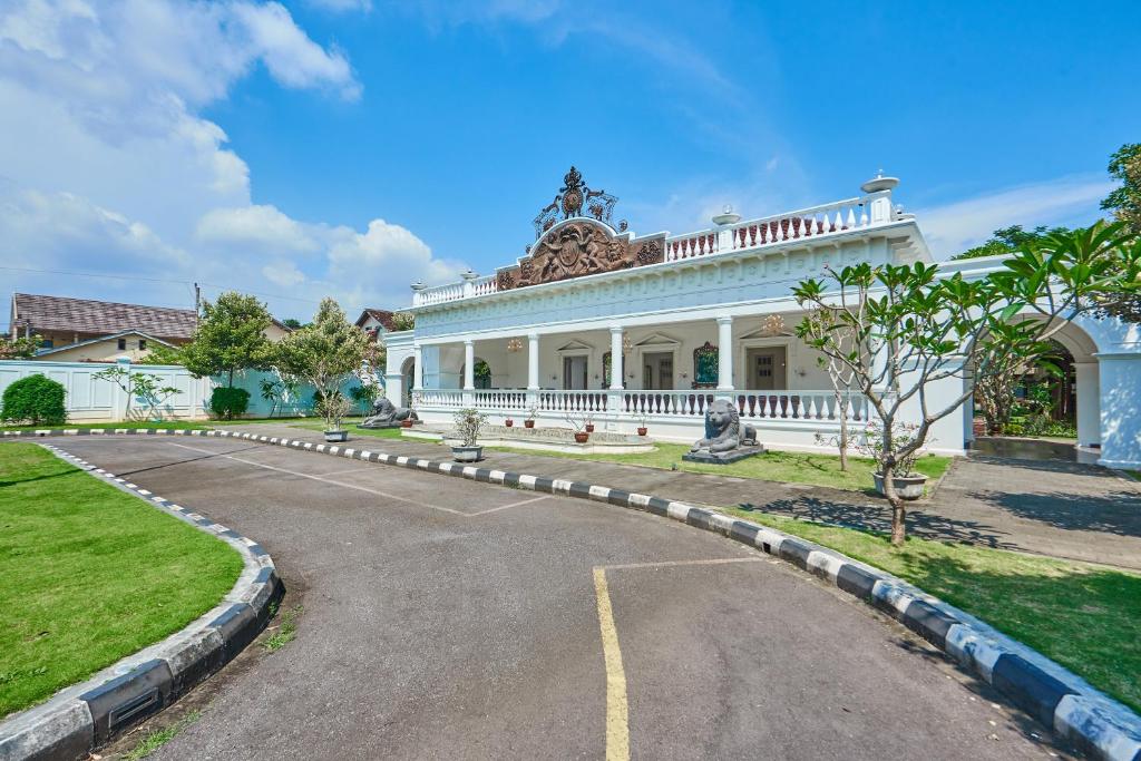 a large white house with a road in front of it at Tirtodipuran Hotel Yogyakarta in Timuran