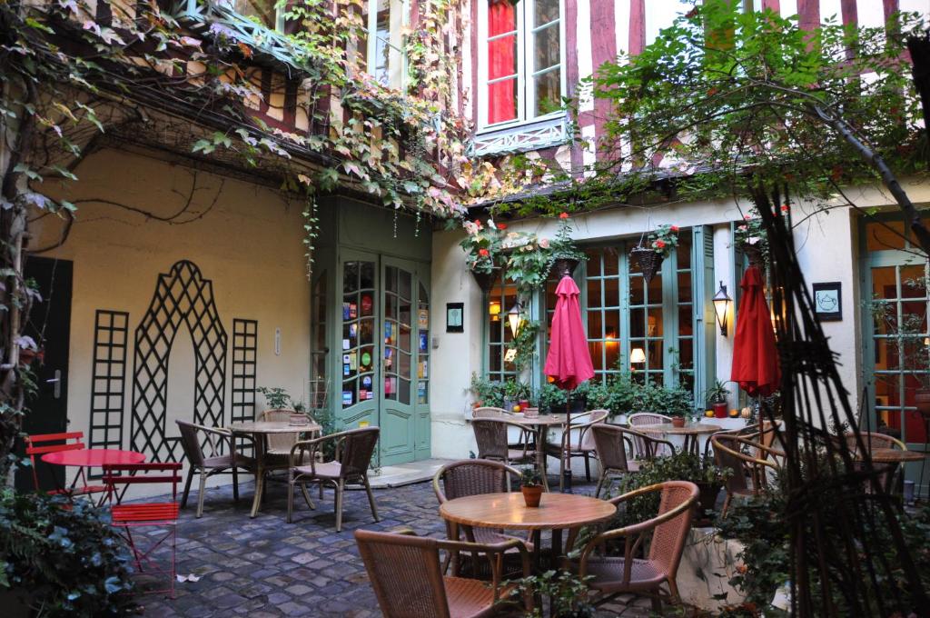 Le Vieux Carré في رووين: فناء في الهواء الطلق مع طاولات وكراسي في مبنى