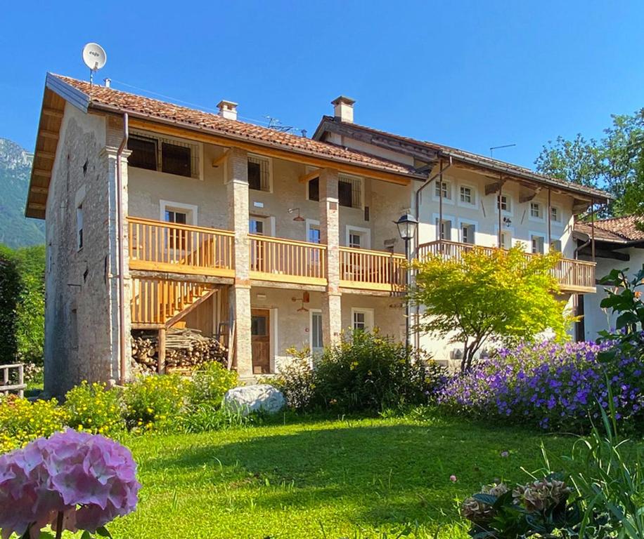 een groot huis met een balkon en een tuin bij Casa del Piol Fattoria dei fiori in Sospirolo