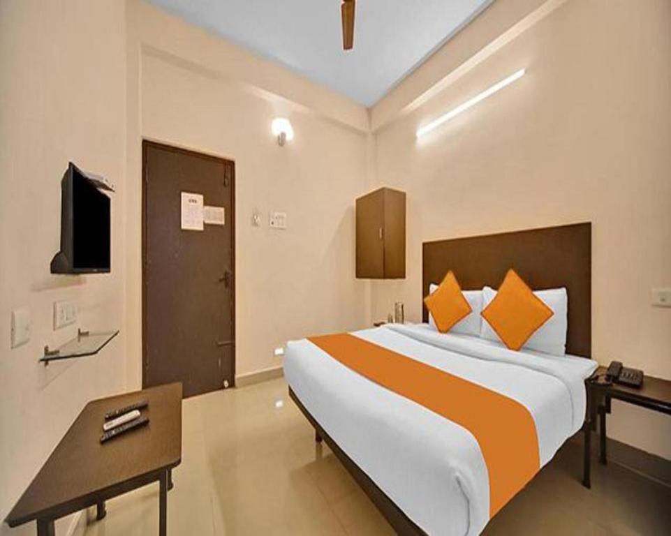 a bedroom with a large bed and a television at FabExpress Joel Inn in Chennai