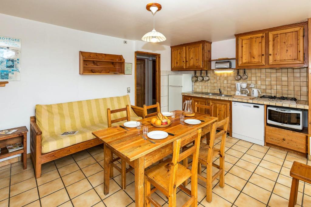 アルヴィユーにあるAppartement de 3 chambres avec jardin clos et wifi a Arvieux a 1 km des pistesのキッチン(木製テーブル付)、ダイニングルーム