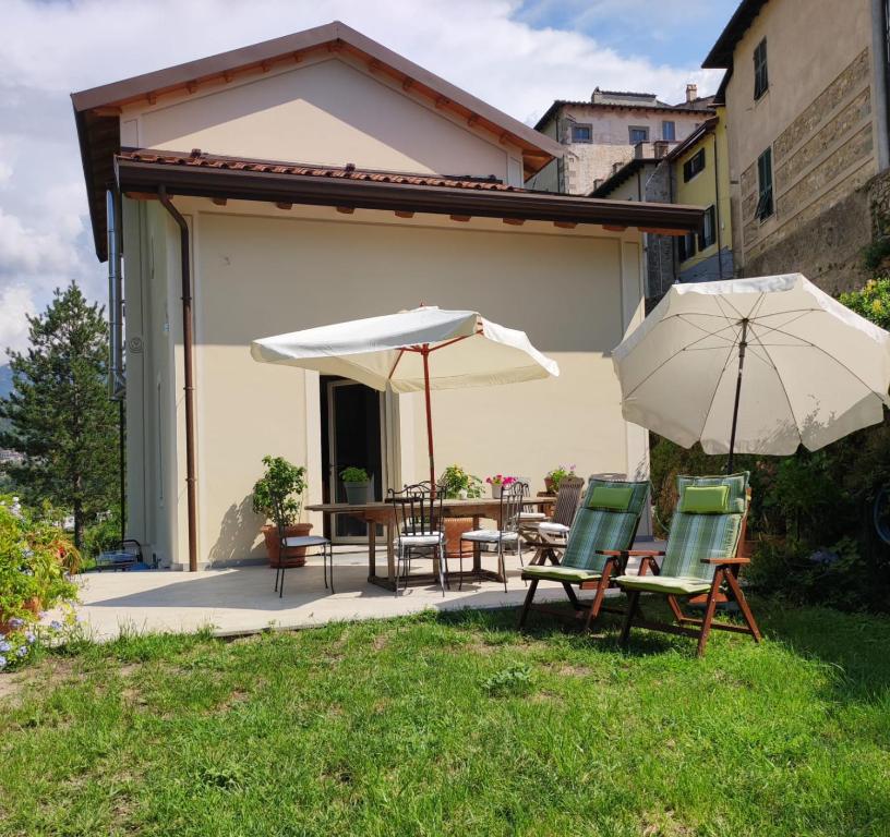 a patio with two umbrellas and a table and chairs at CantoQuinto Bed and Breakfast in Fivizzano