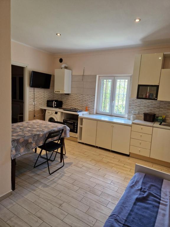 a kitchen with white cabinets and a table in it at FARE BnB - casetta sul fiume in città in Reggio Emilia