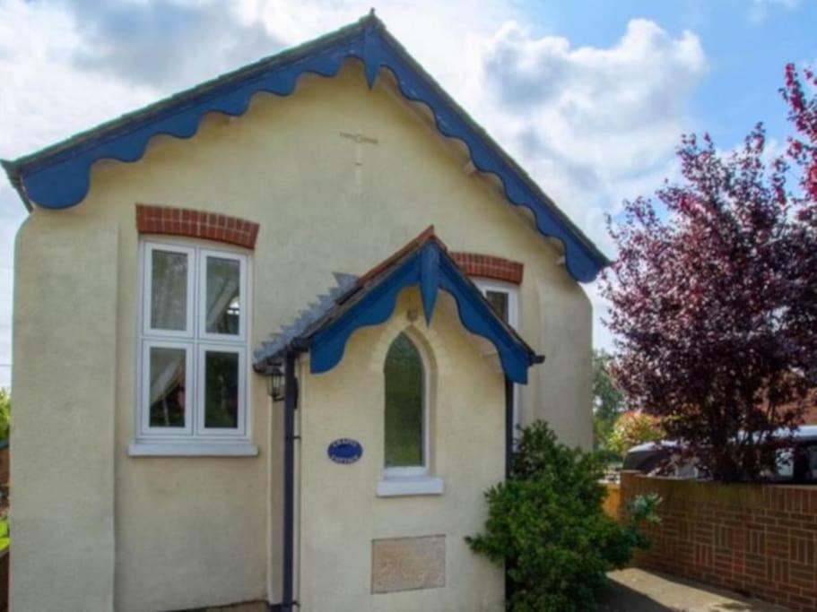 a small house with a blue roof at Chapel Cottage in Canterbury