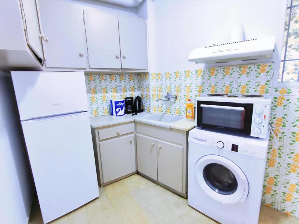 a kitchen with a washing machine and a refrigerator at Neat department in Athens
