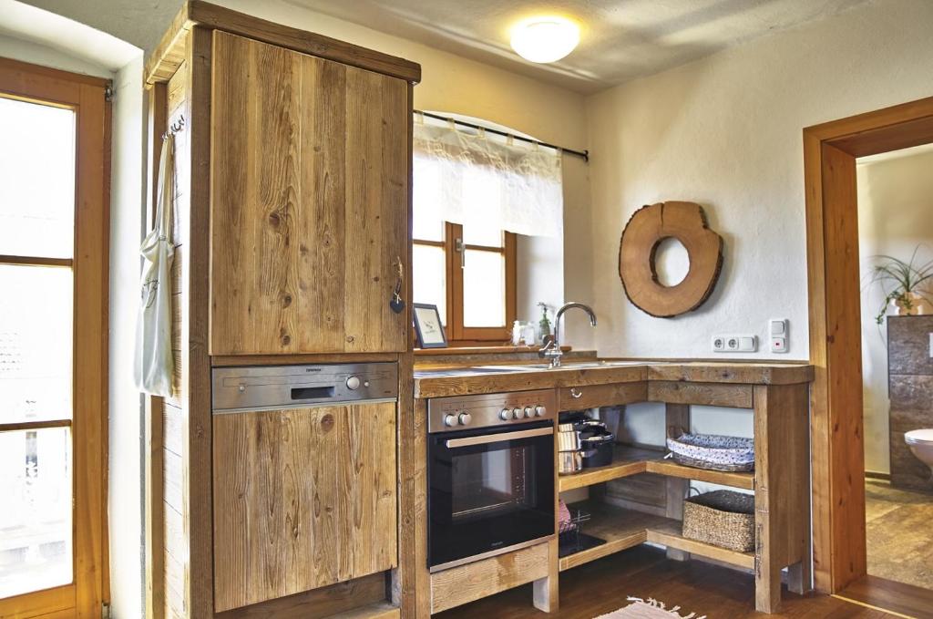 a kitchen with wooden cabinets and a sink at Bio-Ferienhof Höfler in Untergriesbach