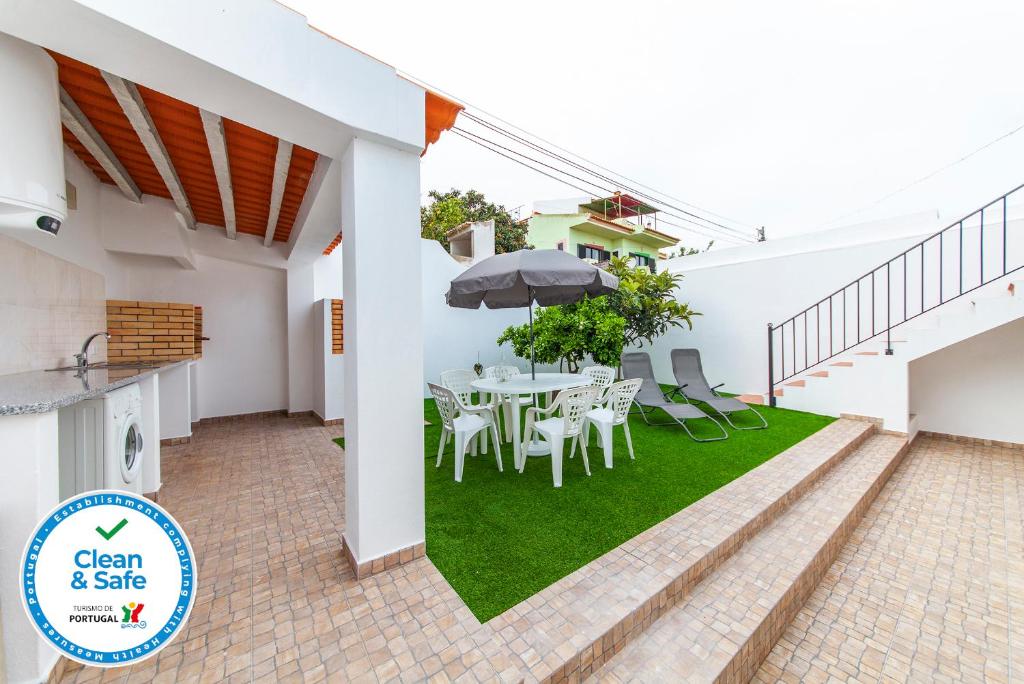 ラゴスにあるCarrob Street Houseのテーブルと椅子と傘のあるパティオ